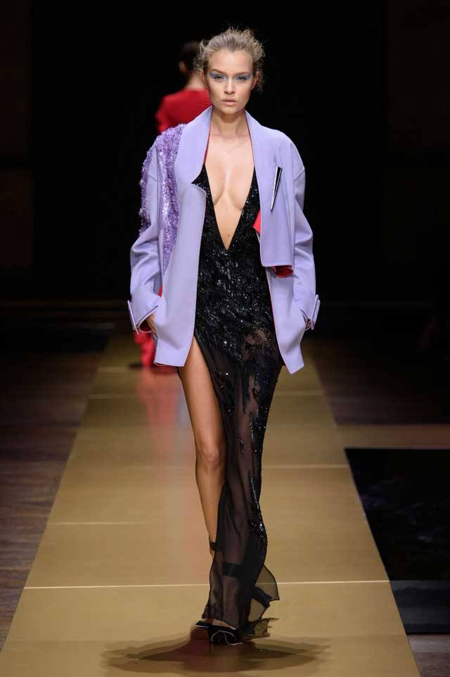 Модный вечерний лук – светло-сиреневый пиджак с блестками и прозрачное платье с высоким разрезом контрастного черного цвета