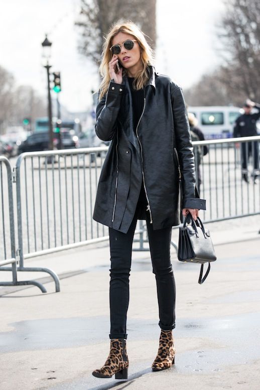 Черный свитер в сочетании с черными скинни, кожаной курткой оверсайз, леопардовыми ботинками на толстом маленьком каблуке, кожаной черной сумкой и очками.