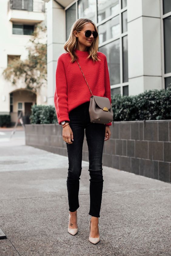 На девушке красный свитер, заправленный в черные скинни, бежевые лодочки на высоком каблуке с заостренным носом, поясная сумка и очки.