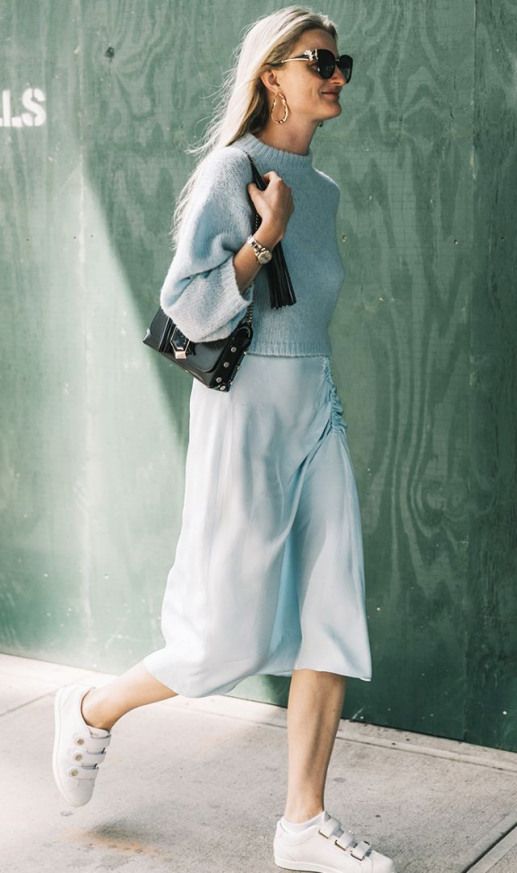 Бирюзовый короткий свитер, надетый поверх такого же цвета атласного прямого платья ниже колена, в сочетании с белыми кедами, черной сумкой и очками.